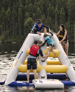 Une famille jouant dans un jeu gonflable sur un lac.