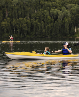 Une mère et sa fille en kayak sur un lac en pourvoirie.