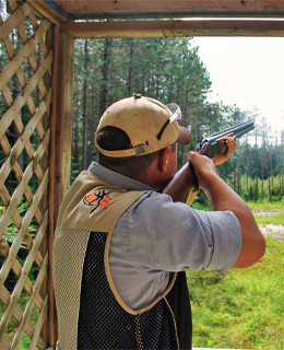 Un homme tirant du pigeon d'argile.