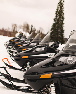 Plusieurs motoneiges stationnées.