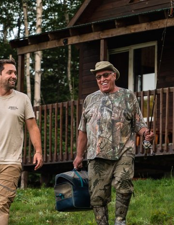 Un pourvoyeur et son client devant un chalet